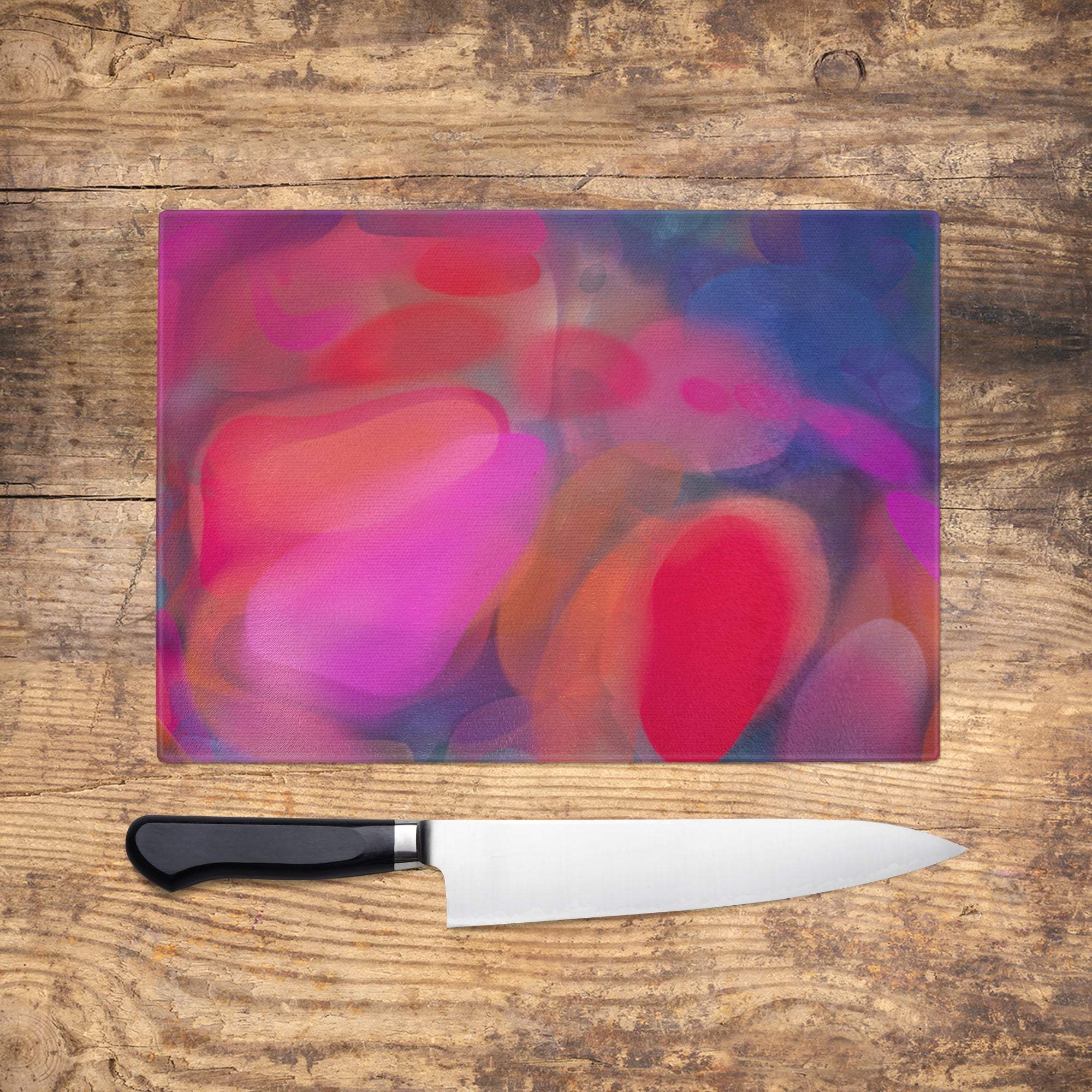 "Gorgeous glass chopping board with vibrant abstract design by Louise Mead, perfect for adding a splash of colour to any kitchen."